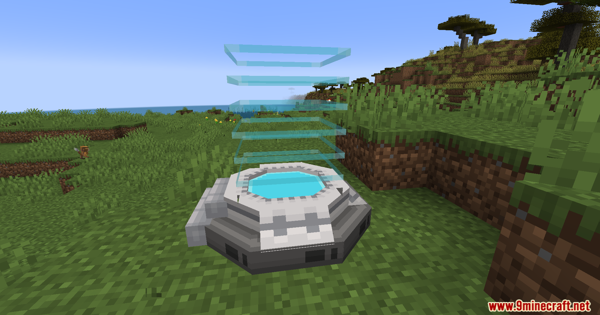 Cobble Safari Mod Screenshot 2 A futuristic circular portal structure with glowing blue rings on a grassy hill