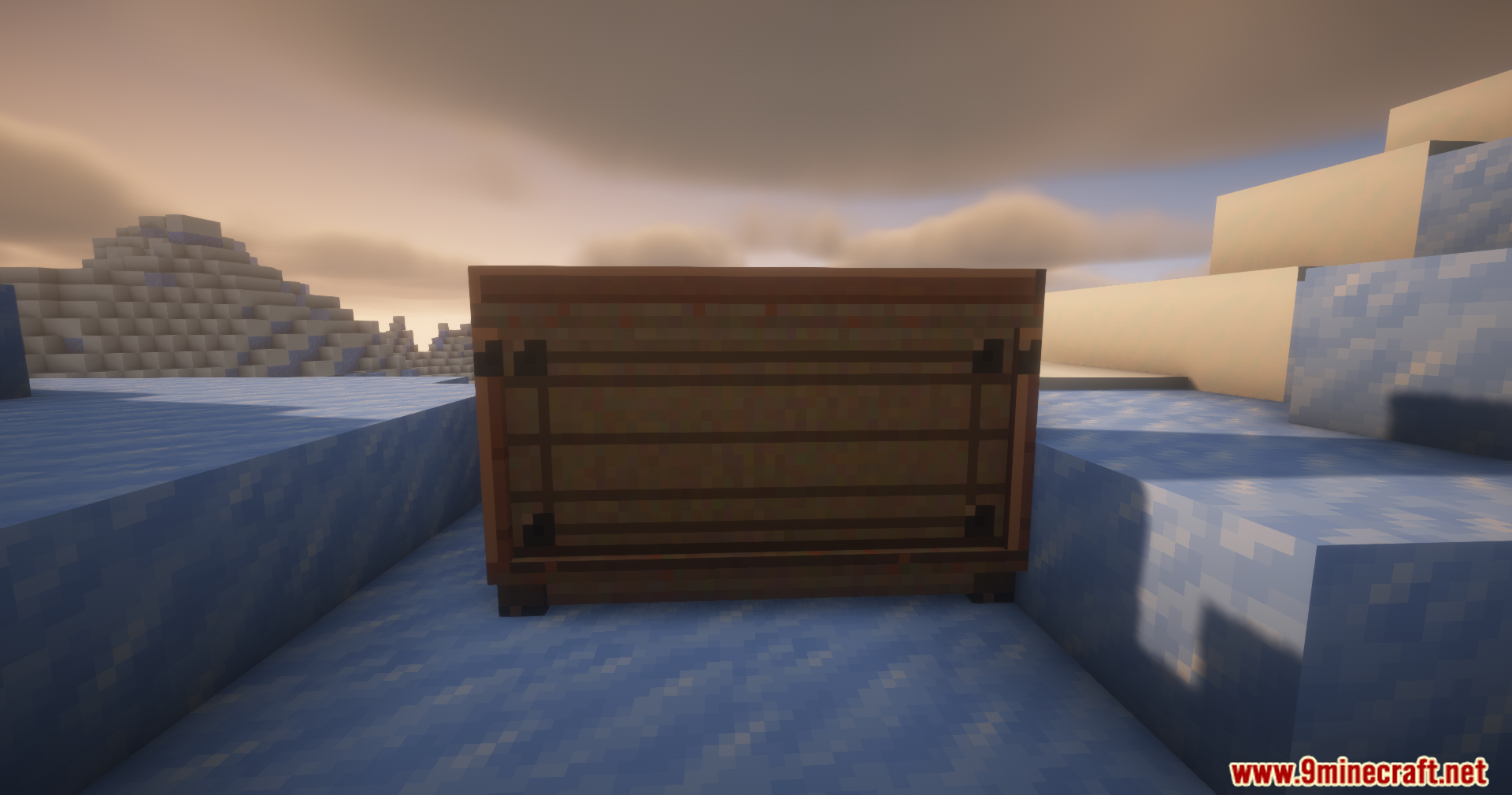 A wooden mission board block placed in a snowy landscape at sunset