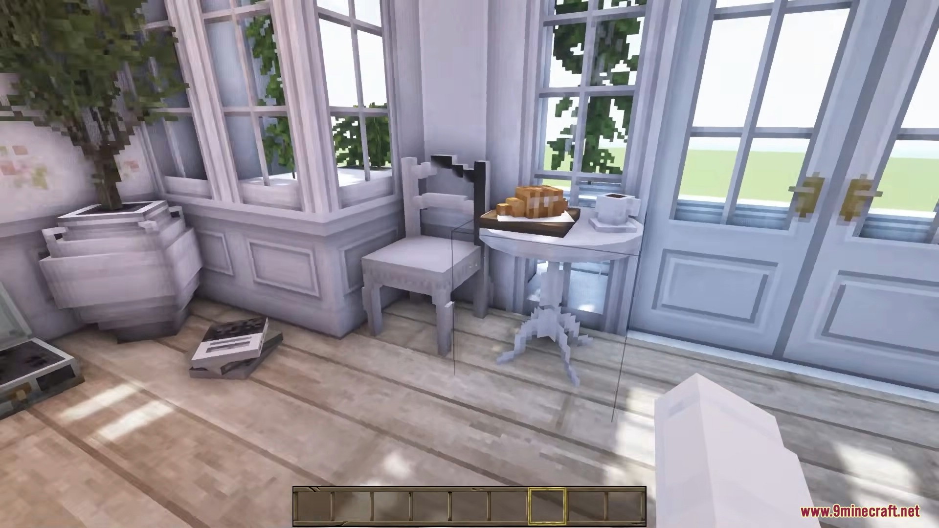 A small white table with bread and coffee next to glass doors