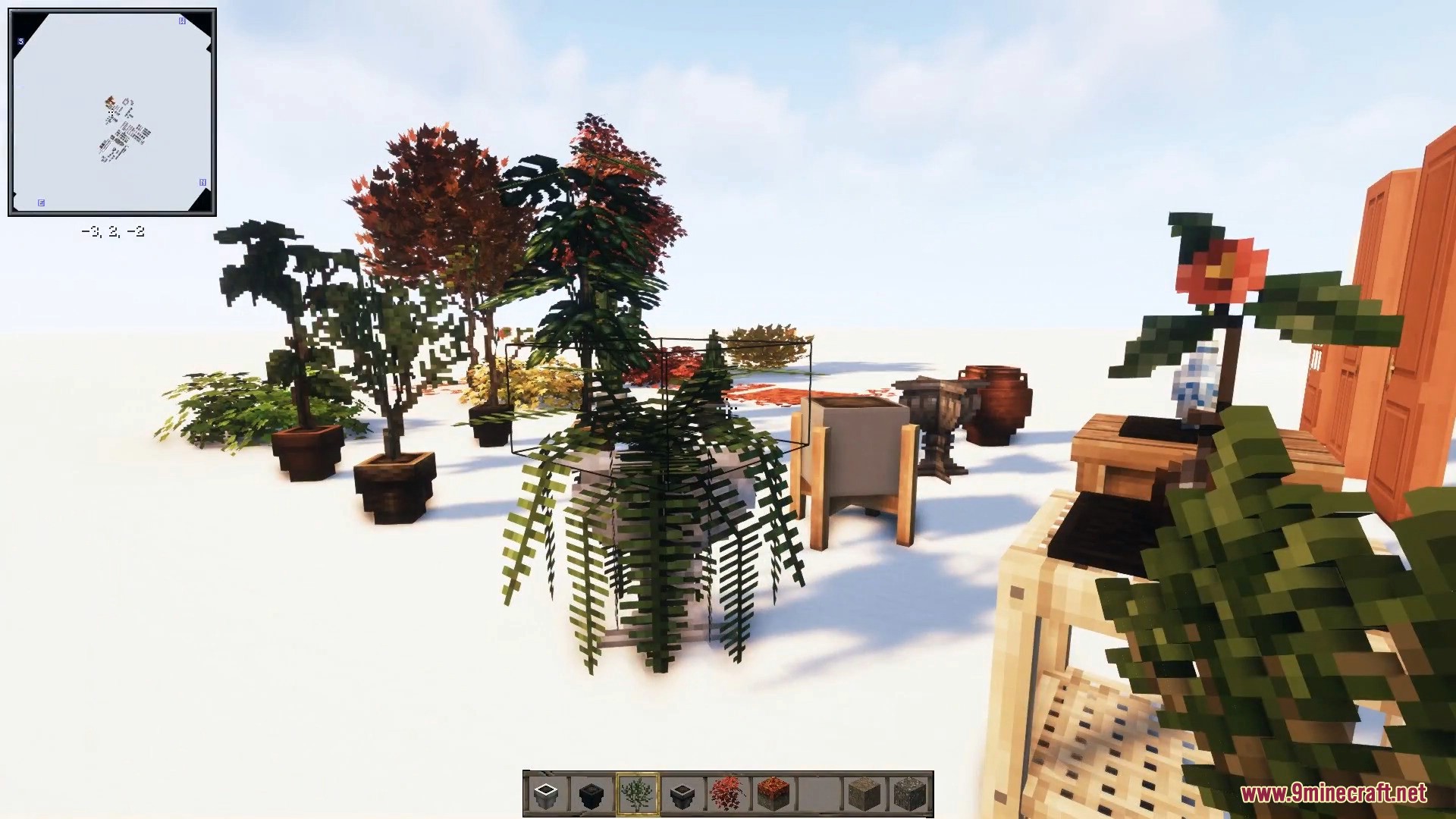 A lovely collection of potted ferns, flowers, and decorative garden stands.