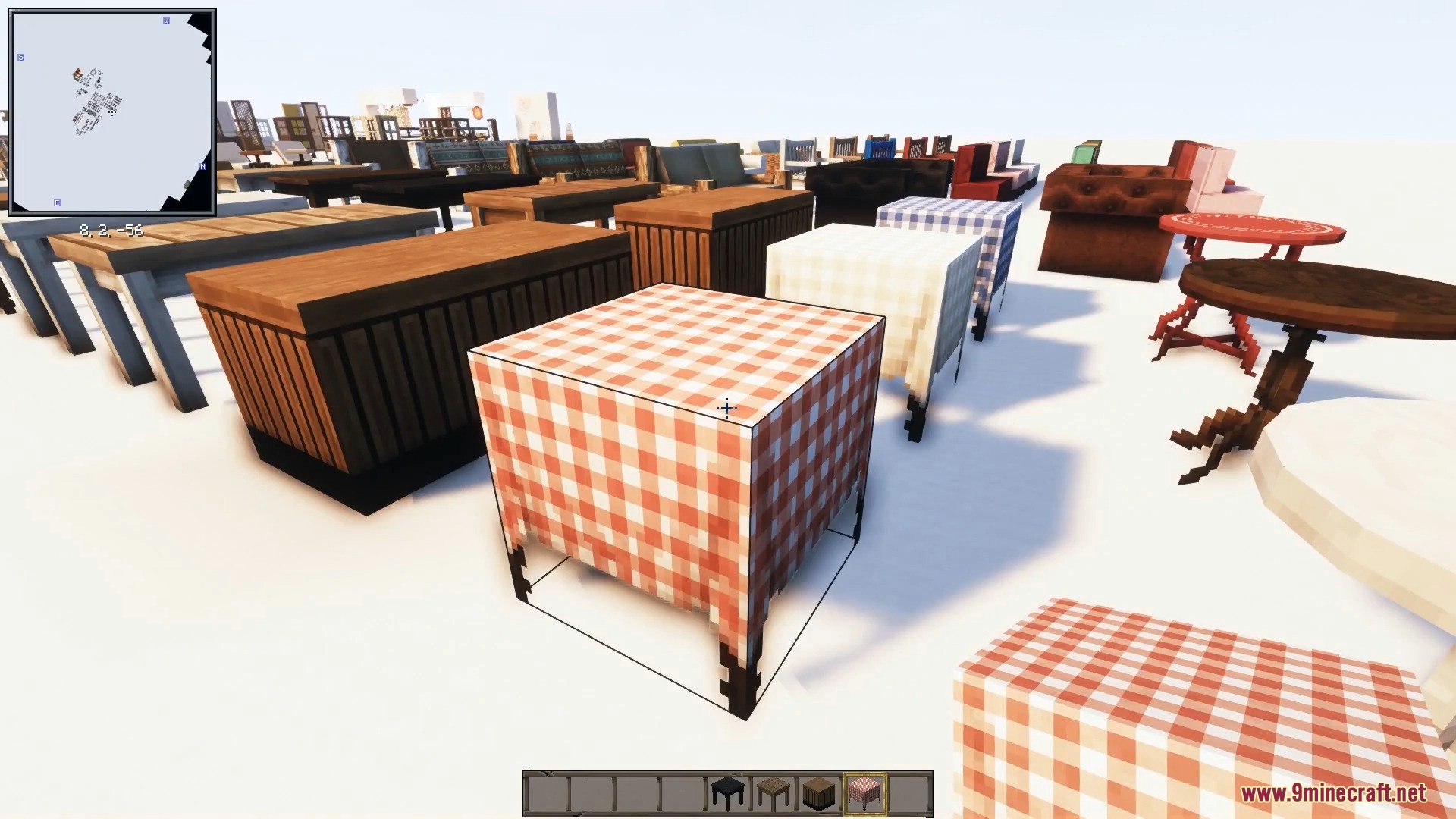 Wooden tables draped in red checkered tablecloths sit near comfortable armchairs.