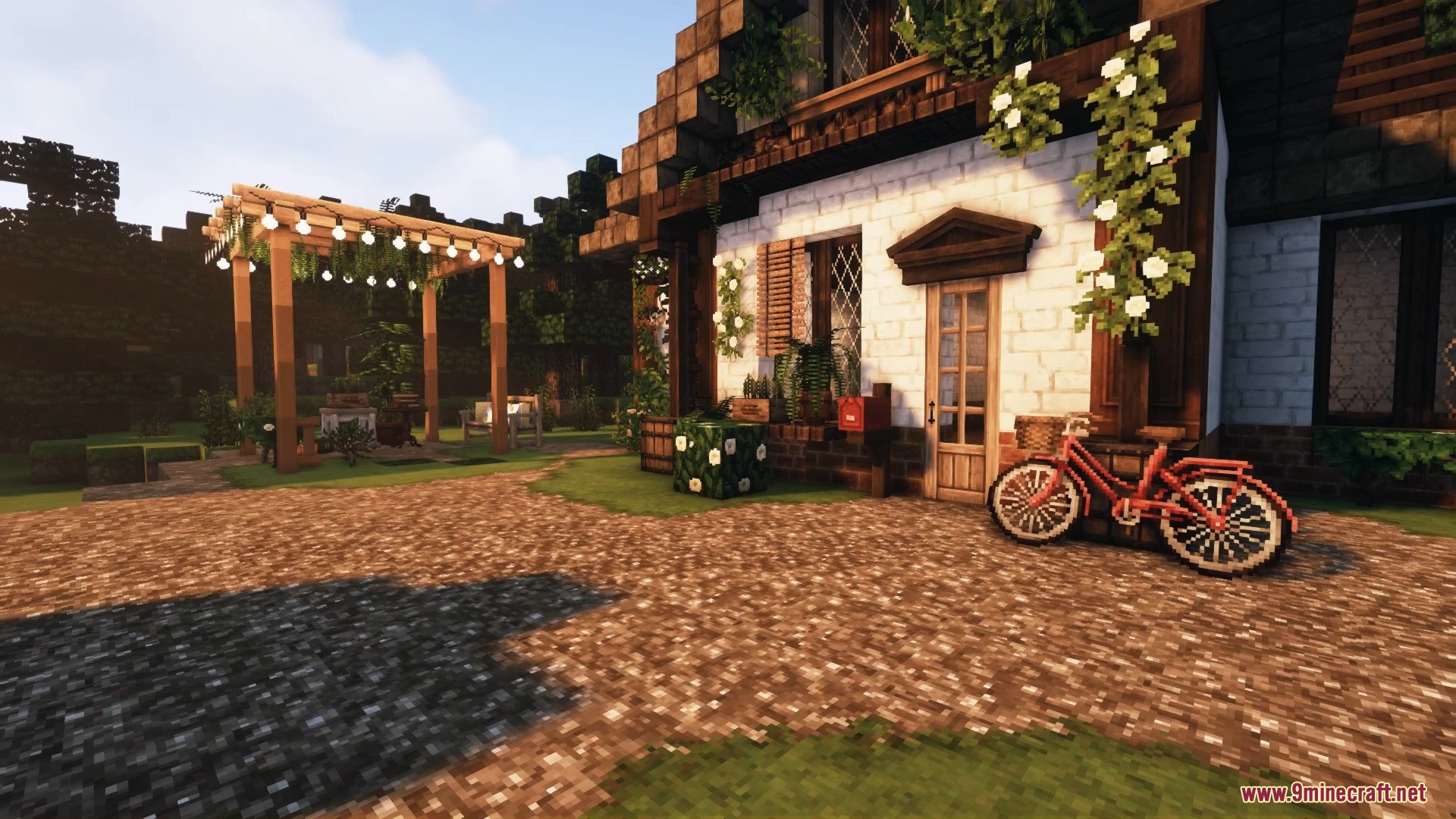 A charming cottage exterior featuring a red bicycle and a lovely garden pergola.