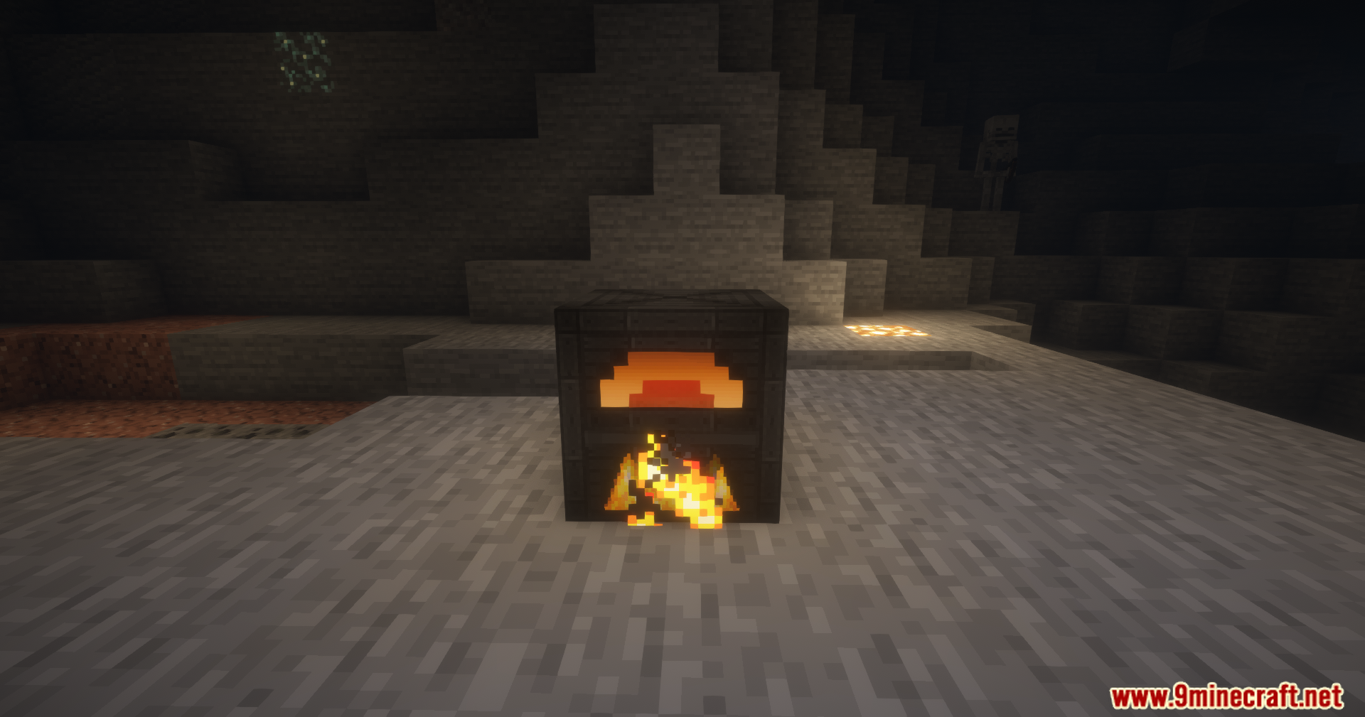 A dark furnace block with a glowing orange face burning inside a cave