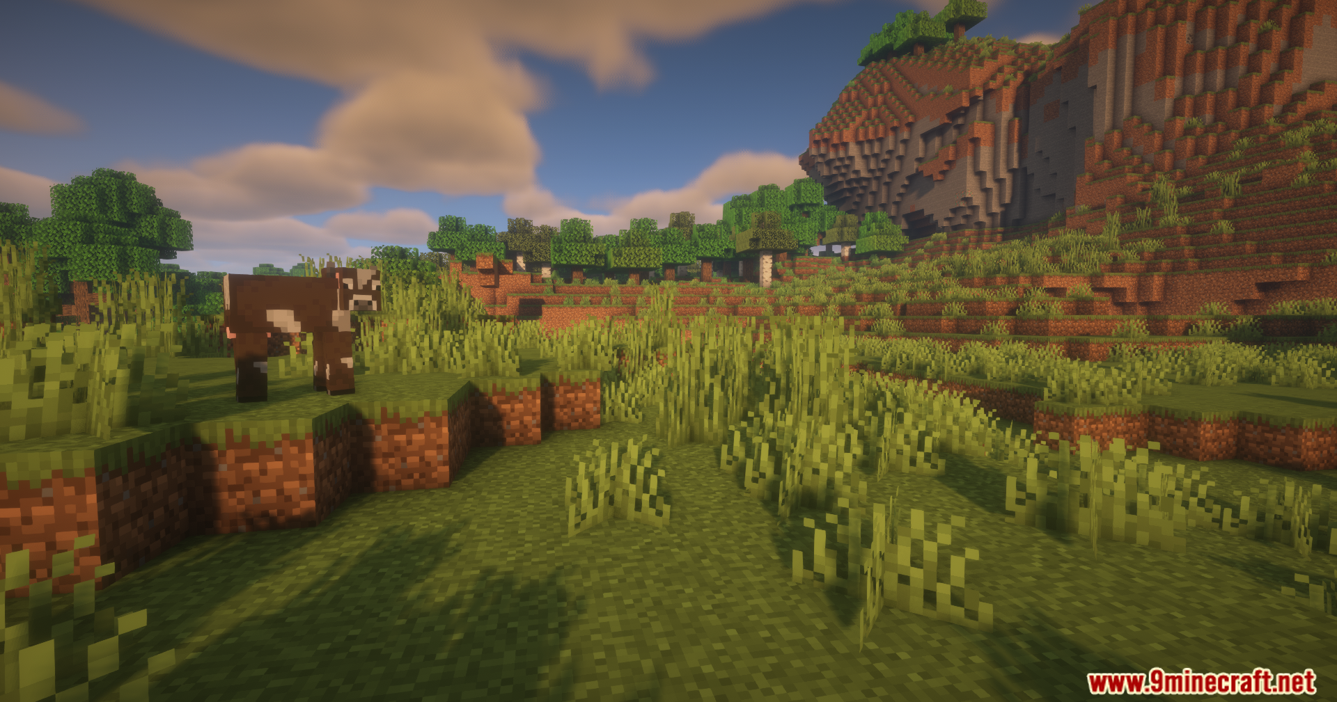 Countered's Smooth F5 Mod Screenshot 9 A cow stands on a grassy hill with mountains and trees in background