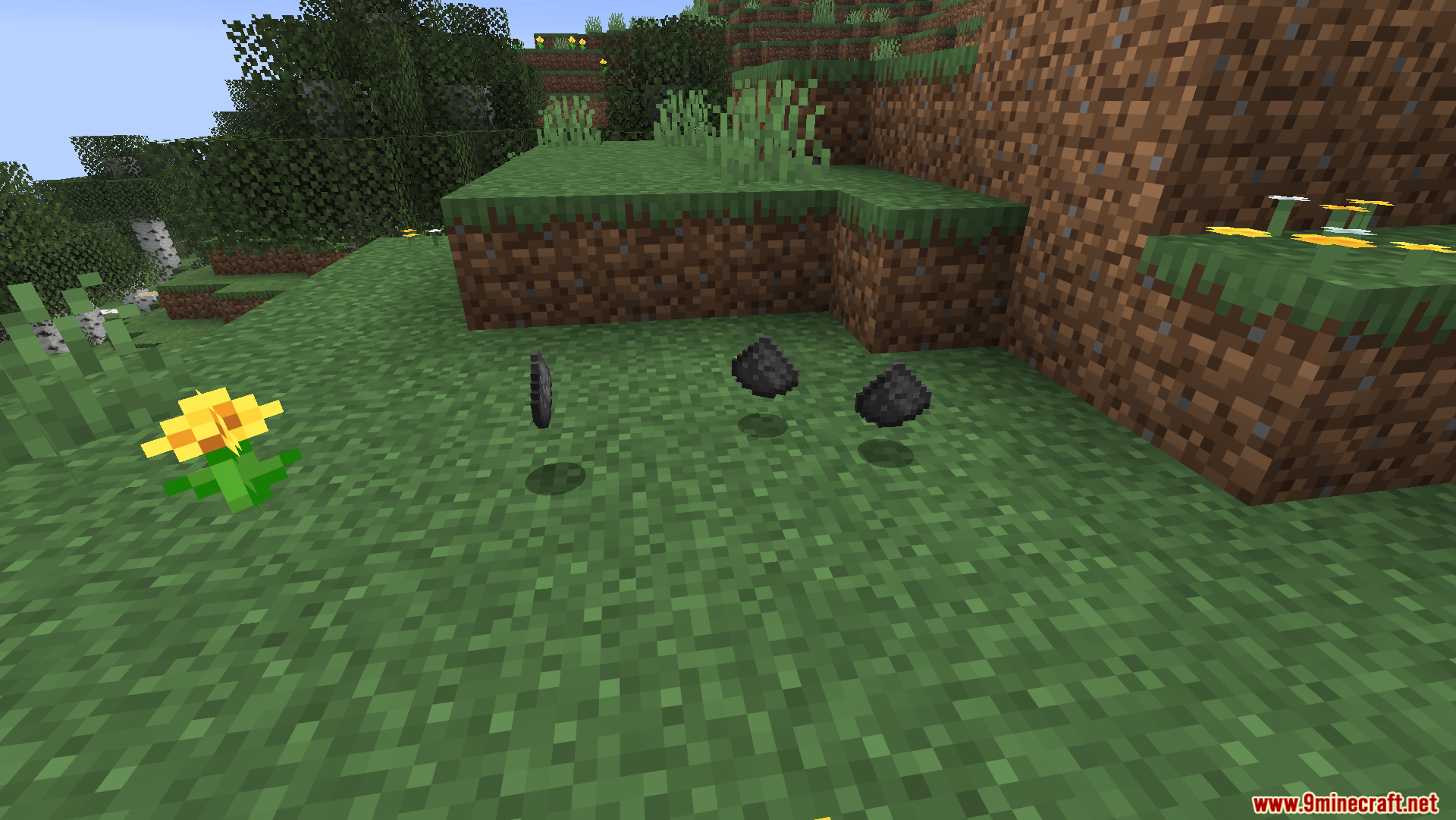 Craftable Gunpowder Recipe Mod Screenshot 5 Three pieces of gunpowder floating on the grass in a Minecraft world