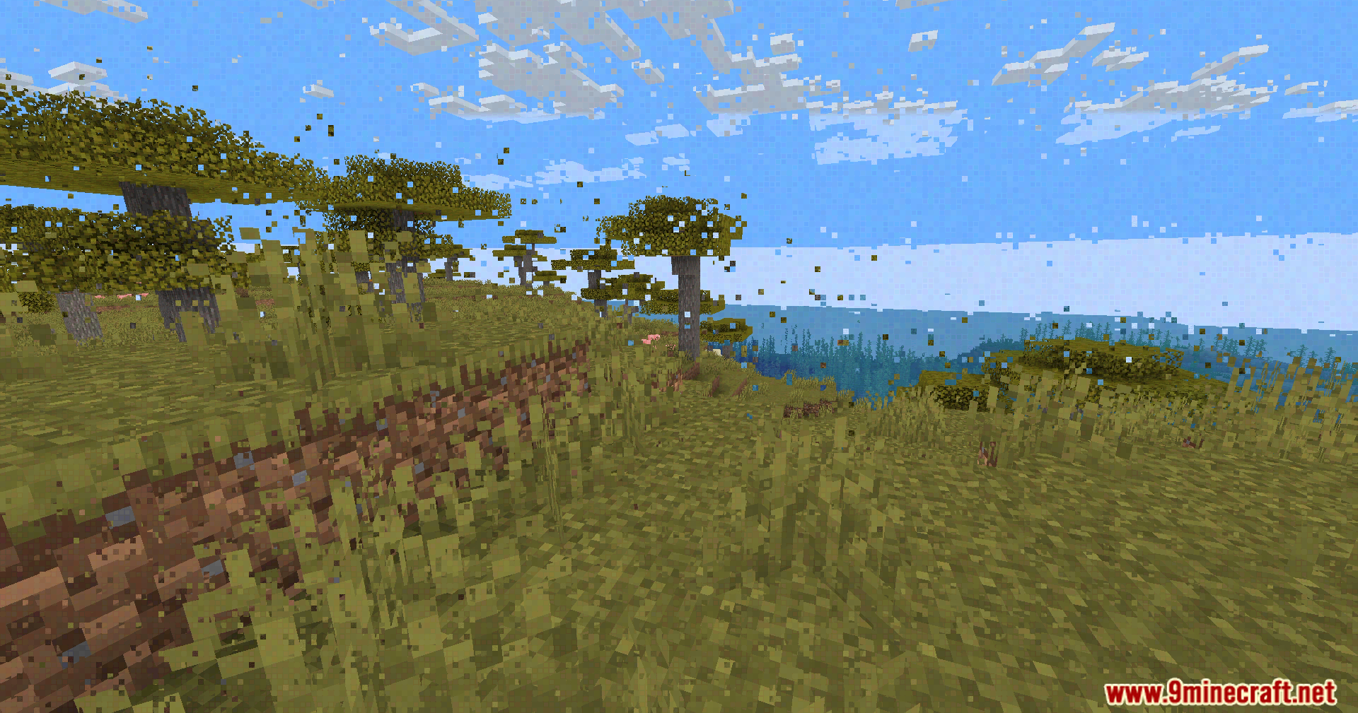 Smearing pixel artifacts cover a grassy landscape near the edge of the sea