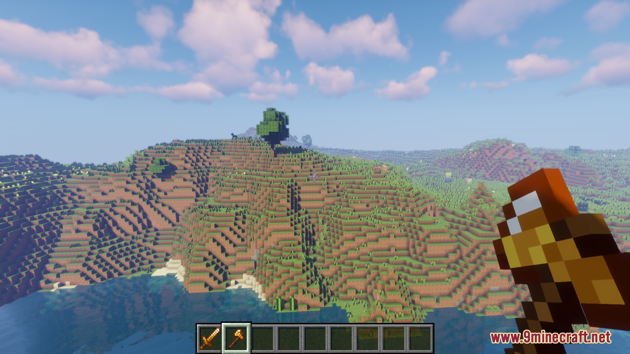 Drodi's Arsenal Resource Pack Screenshot 13 Player holding a golden axe while looking at a grassy Minecraft landscape