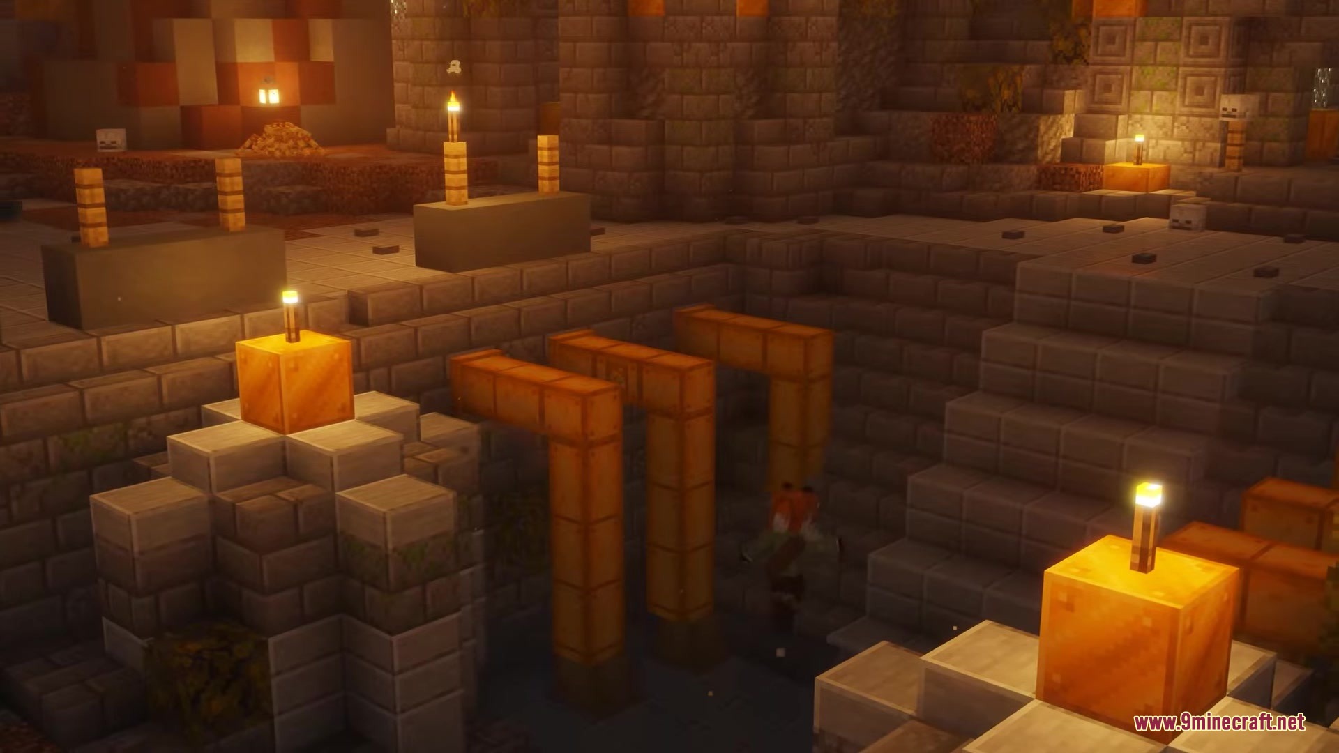 A player explores ancient stone ruins with orange pipes and candles
