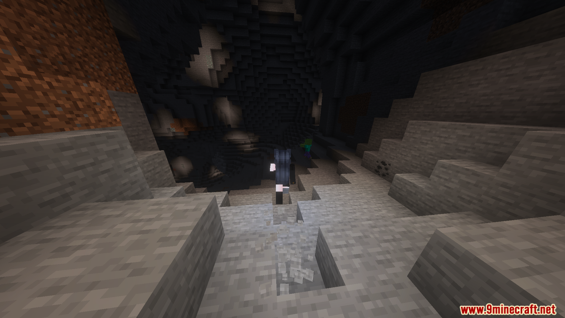 A character walks through a dark cave with a torch in their offhand