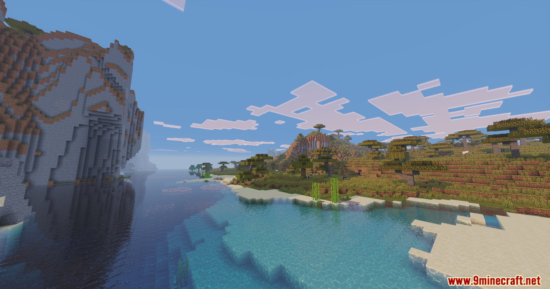 Massive stone cliffs and acacia trees beside a lake with realistic reflections
