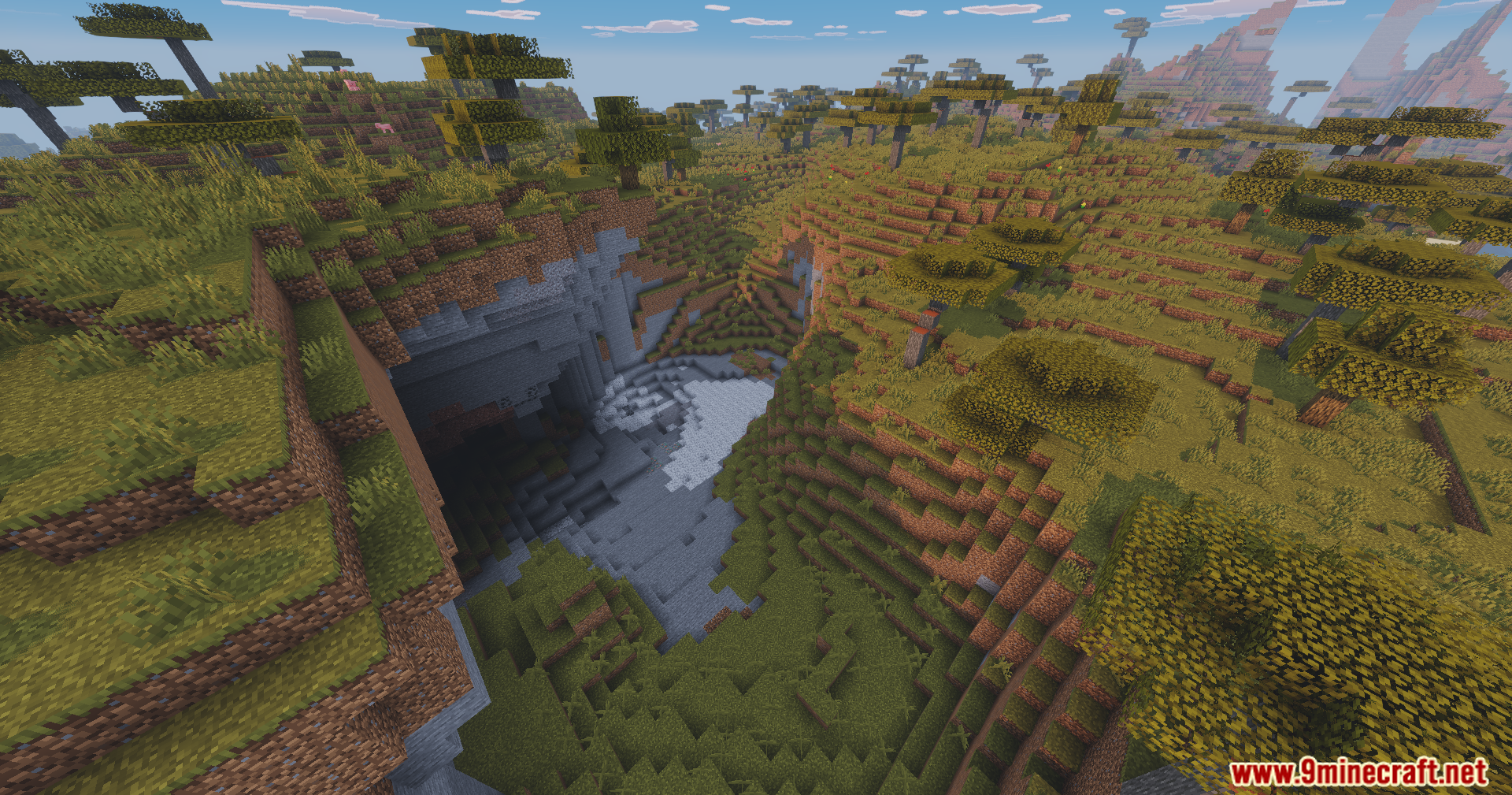 A vibrant savanna landscape featuring a large cave entrance and clear sky