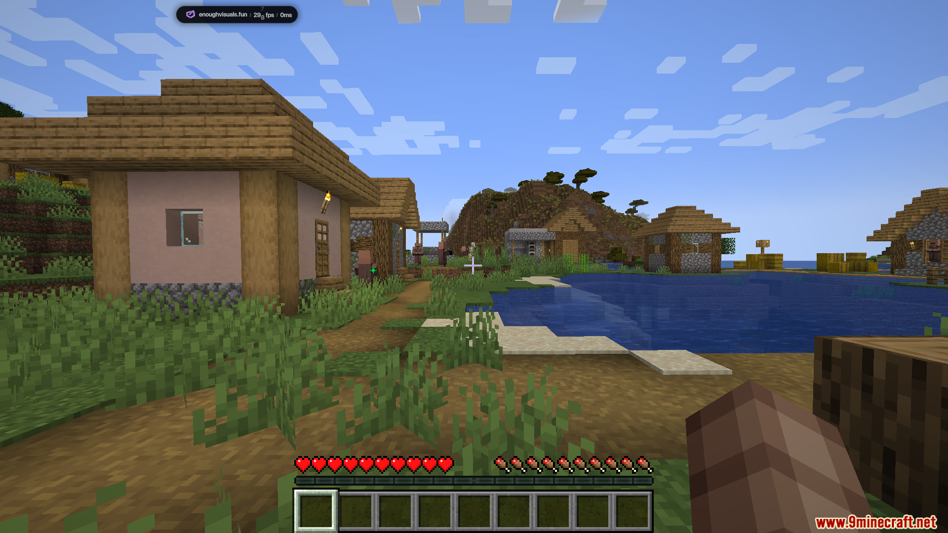 Enough Visuals Mod Screenshot 1 A peaceful Minecraft village with wooden houses and a path near a lake
