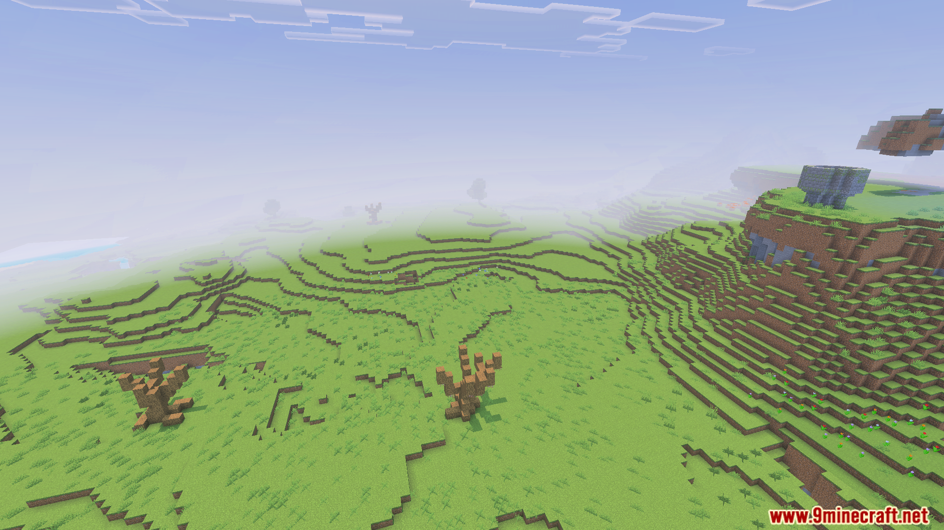A foggy green landscape featuring custom dead trees and a stone structure