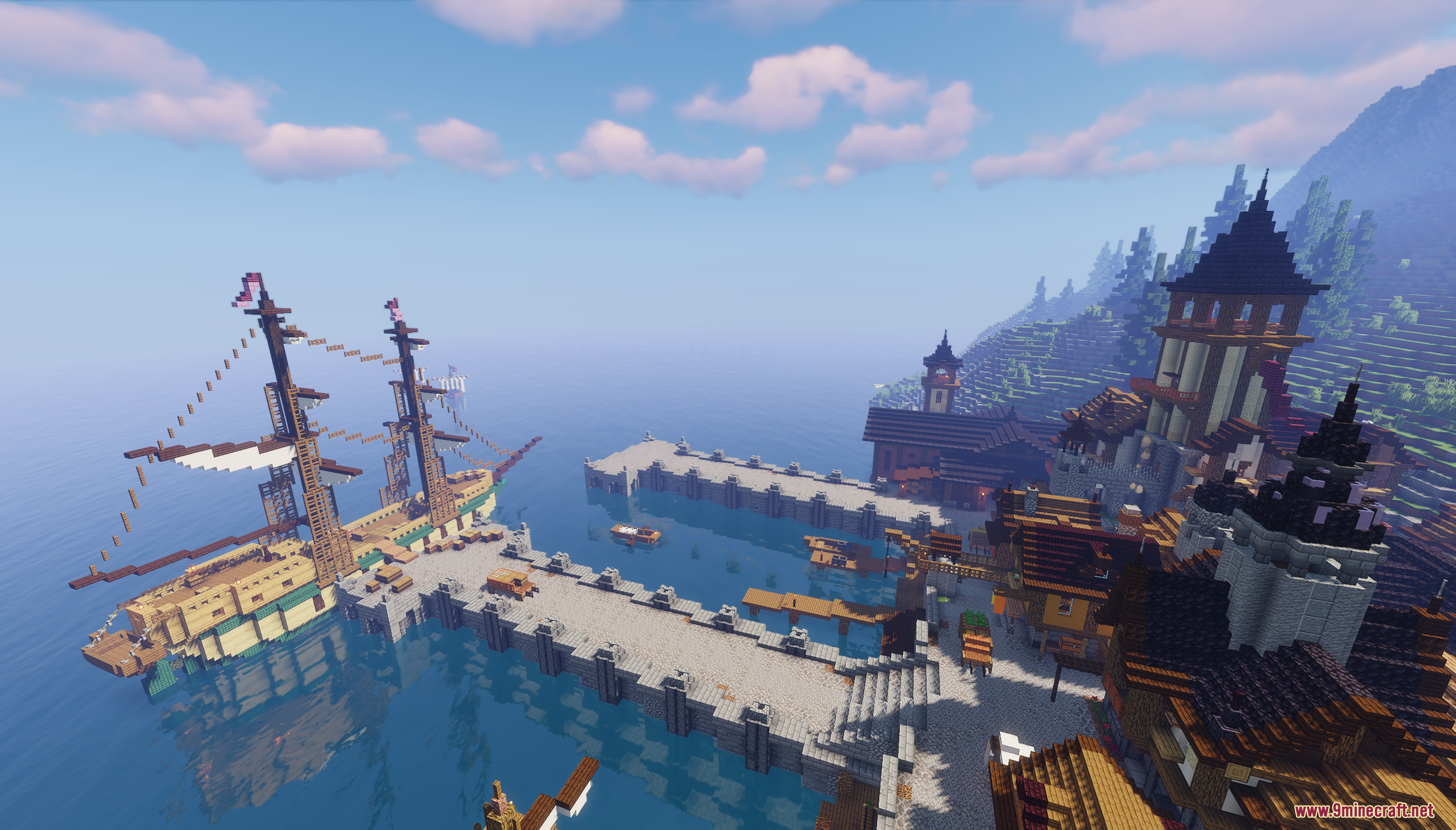 Large wooden sailing ship docked at a stone pier in a coastal harbor