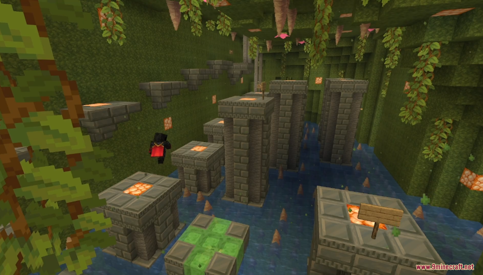 A player jumps across stone pillars in a lush green parkour room