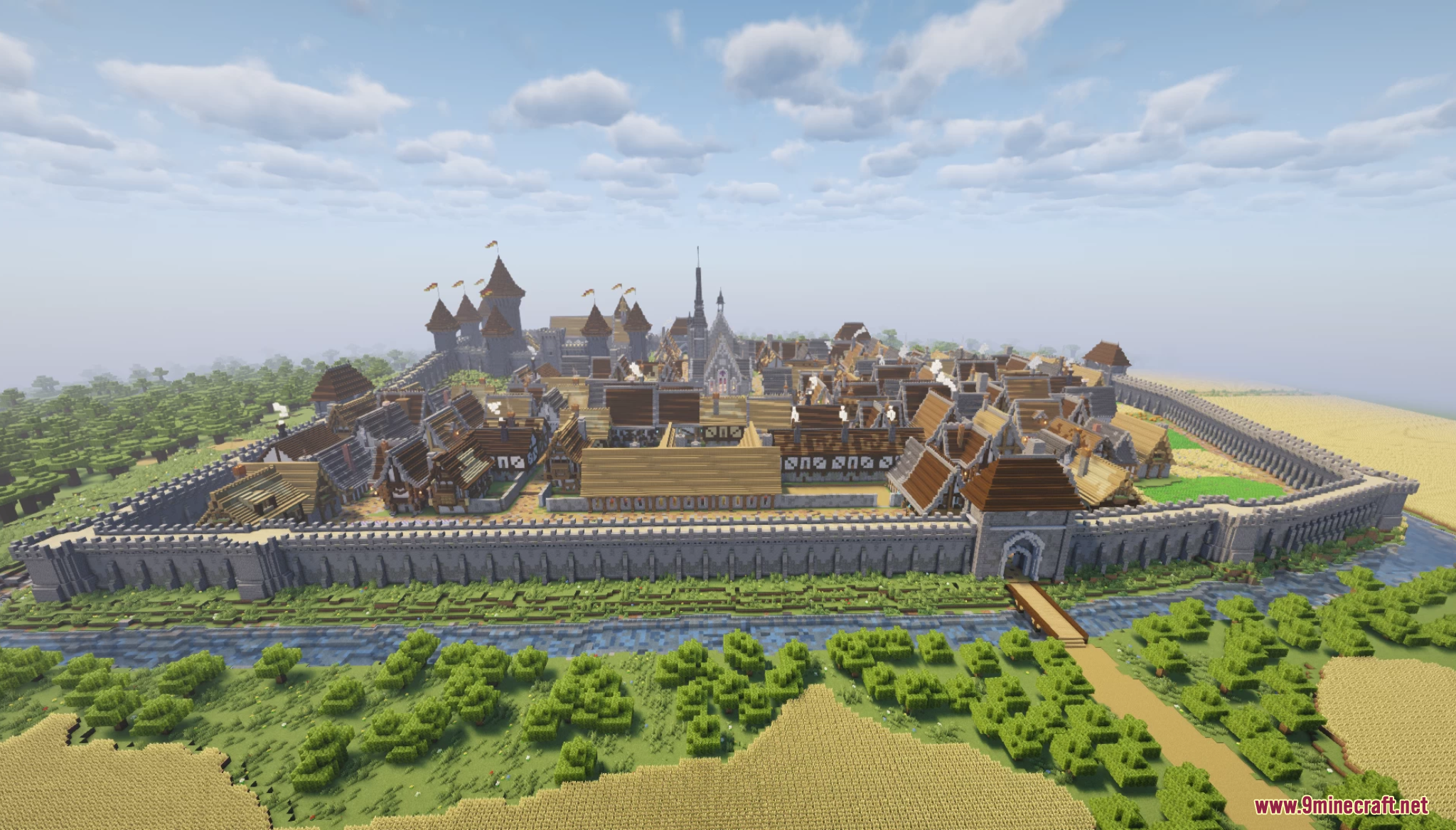 Aerial view of a medieval village with stone walls and a moat