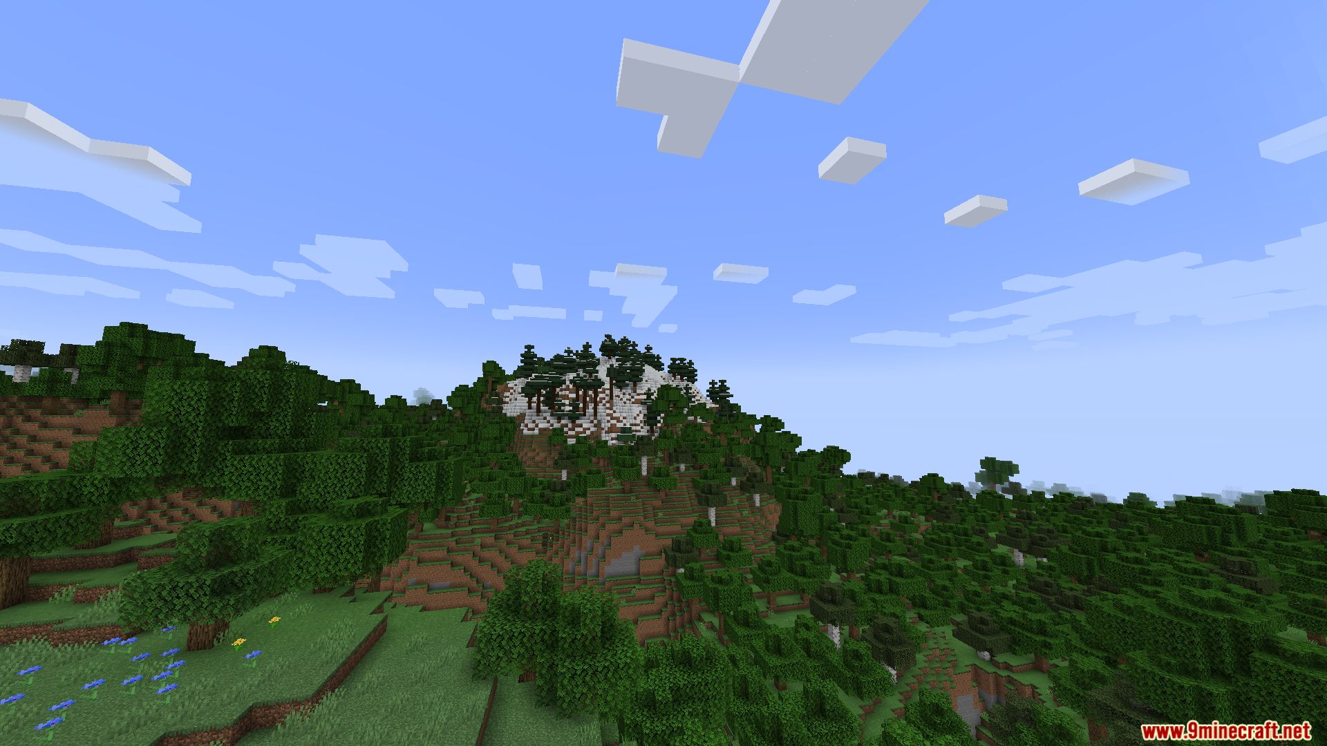 Gnetum Mod Screenshot 7 Scenic Minecraft landscape with green hills and a snowy mountain peak in the distance