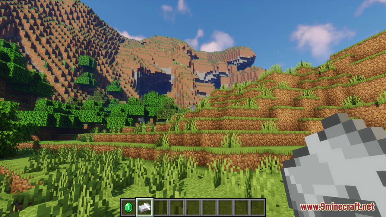 Player holding an animated iron ingot item in a scenic mountain landscape
