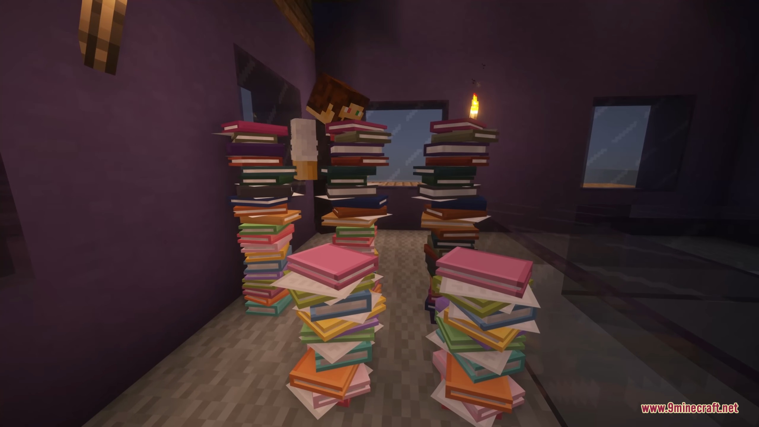 Tall stacks of colorful books arranged on the floor of a purple room