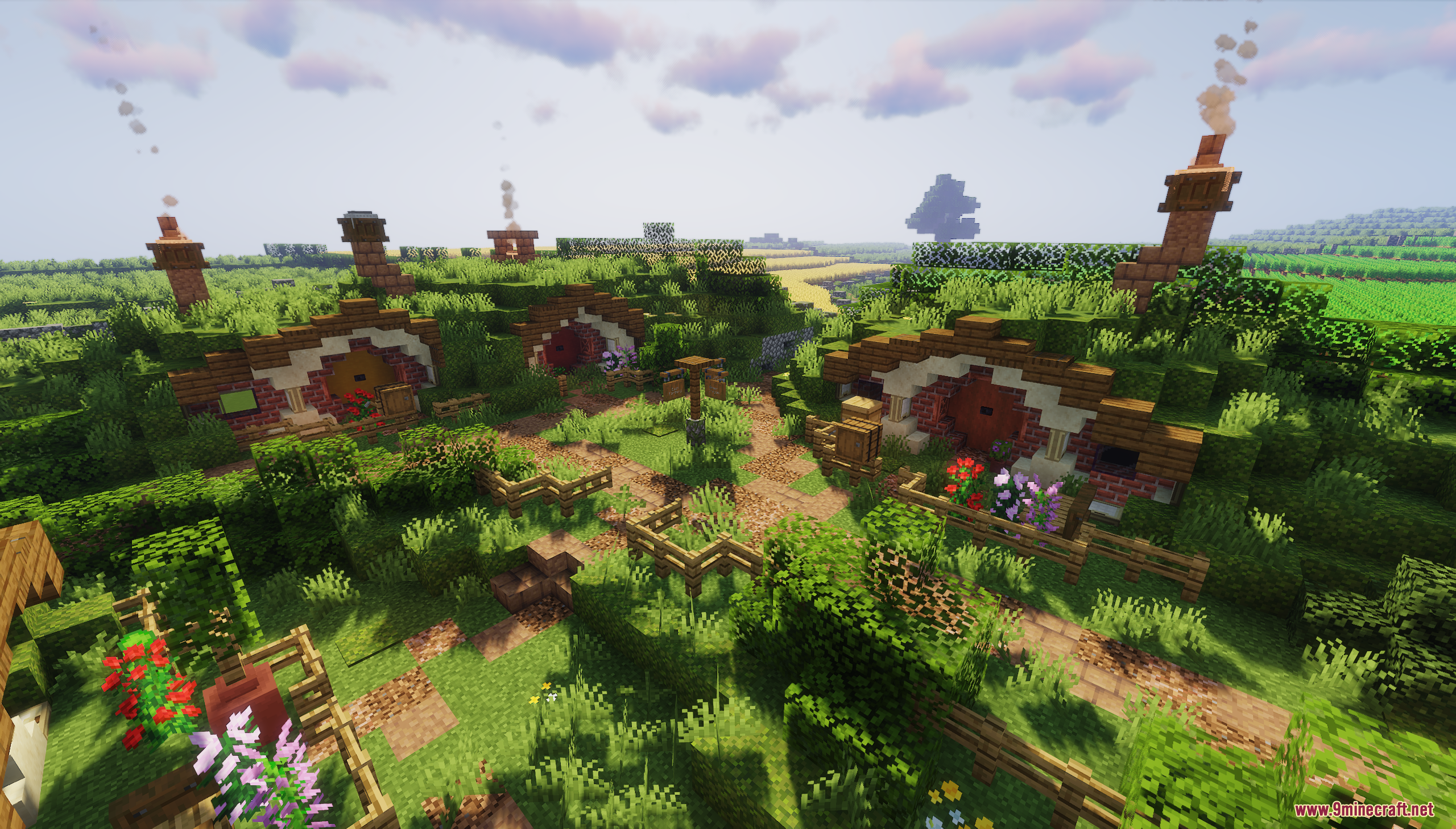 Multiple hobbit houses built into a grassy hill with winding dirt paths
