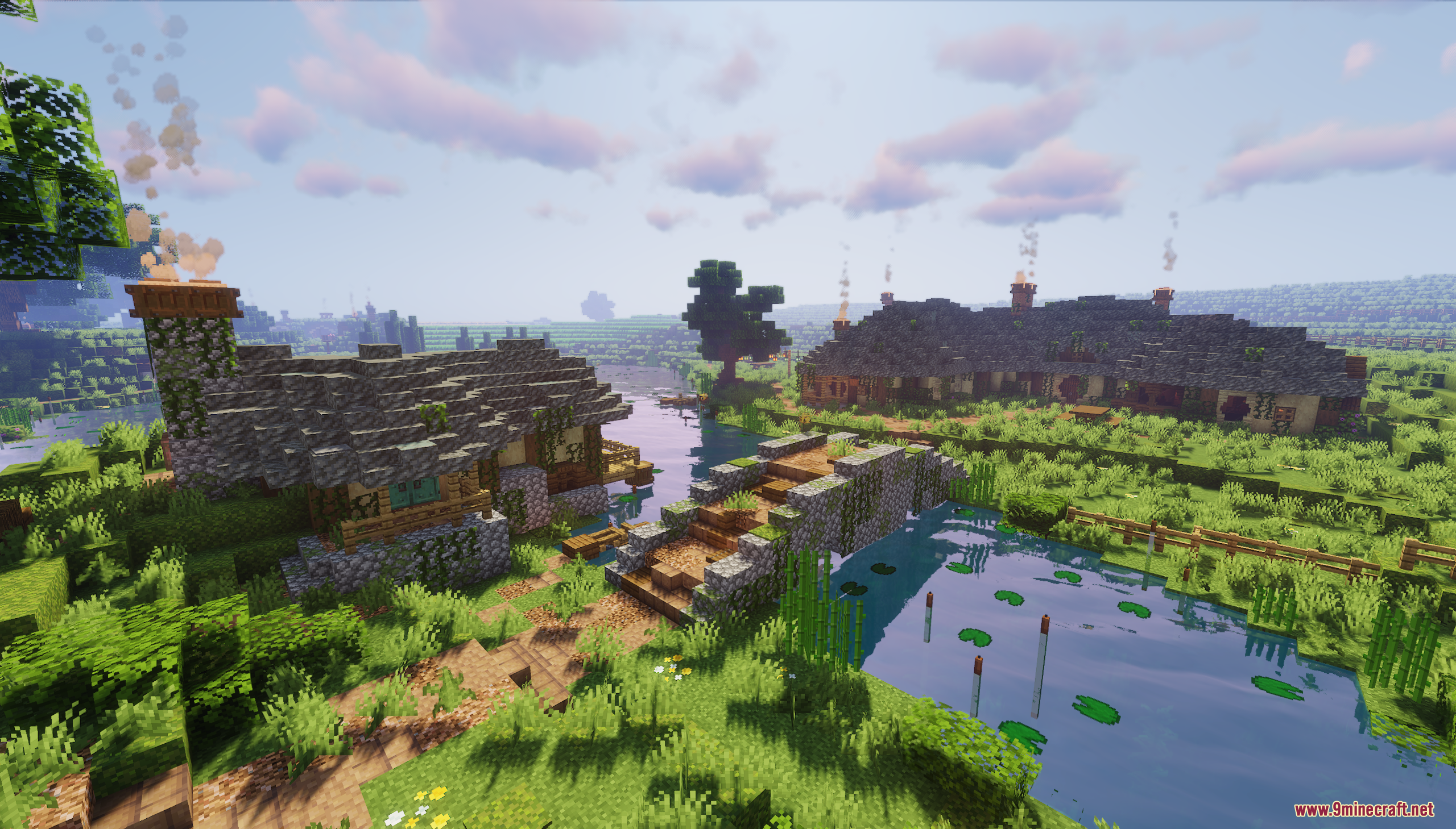 A stone bridge crosses a river surrounded by lush greenery and cozy cottages