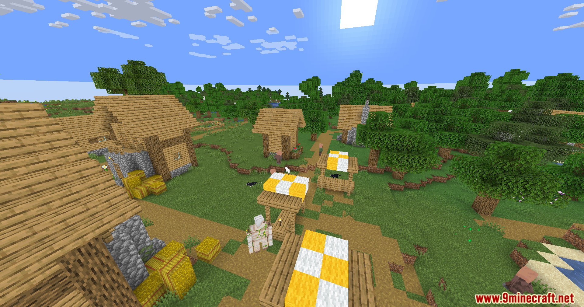 An overview of a village with market stalls and an iron golem