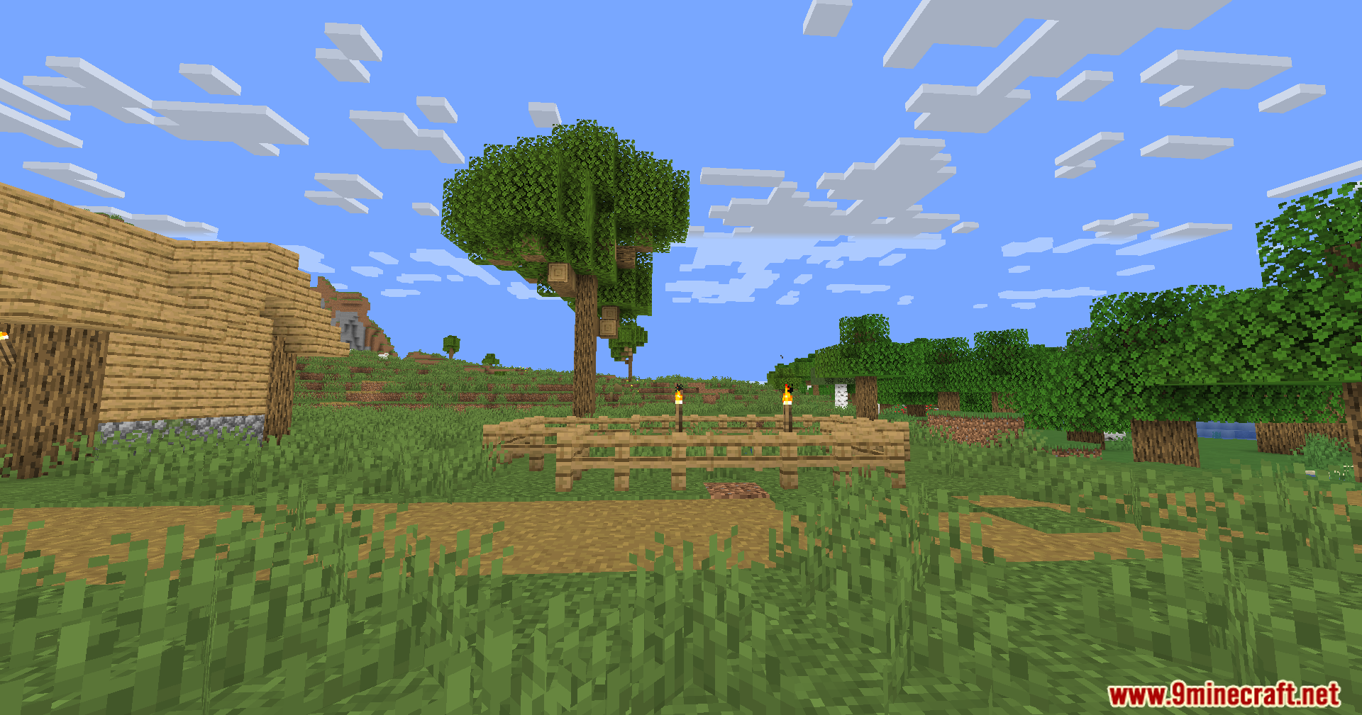 A wooden village house and a fence under a bright blue Minecraft sky