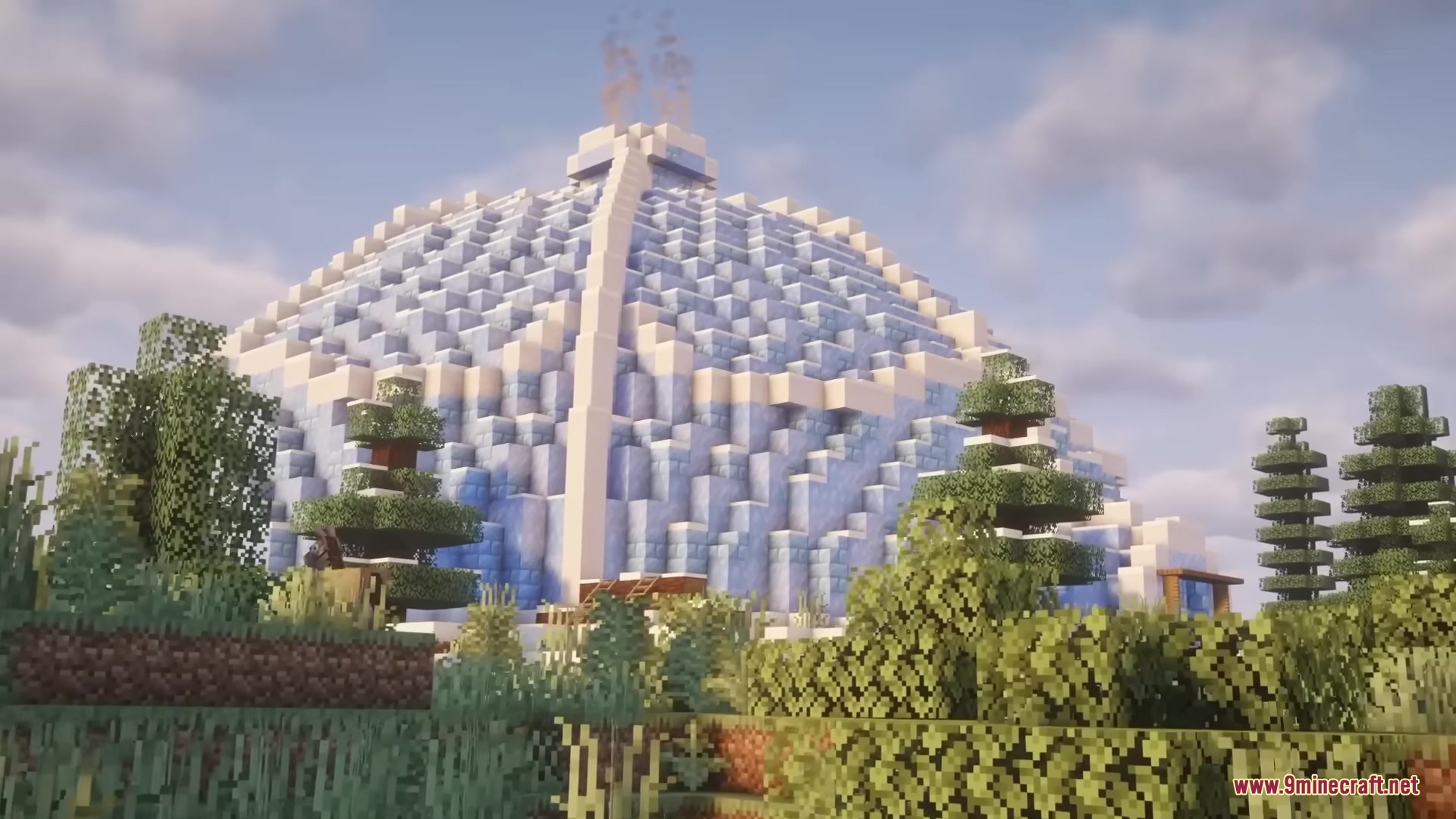 A massive frozen igloo structure stands tall among the forest trees