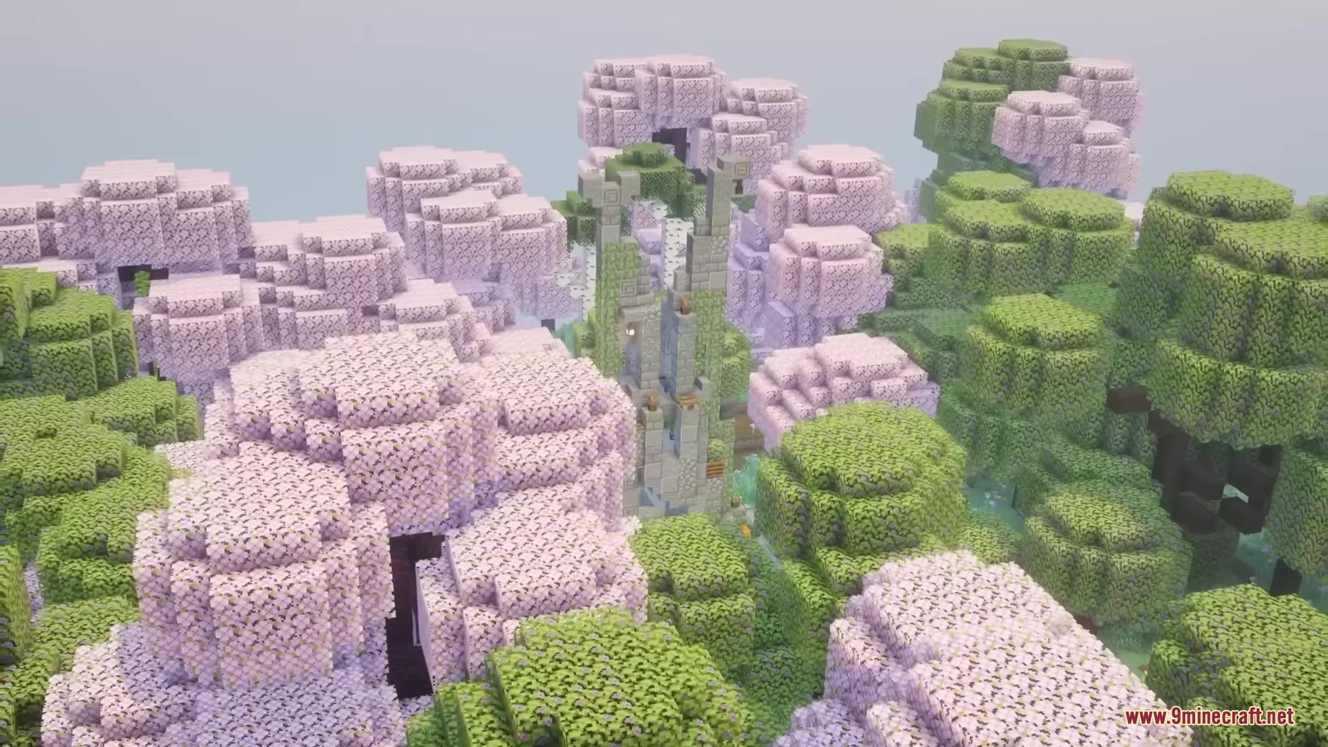 A tall mossy stone tower rises between pink and green forest trees