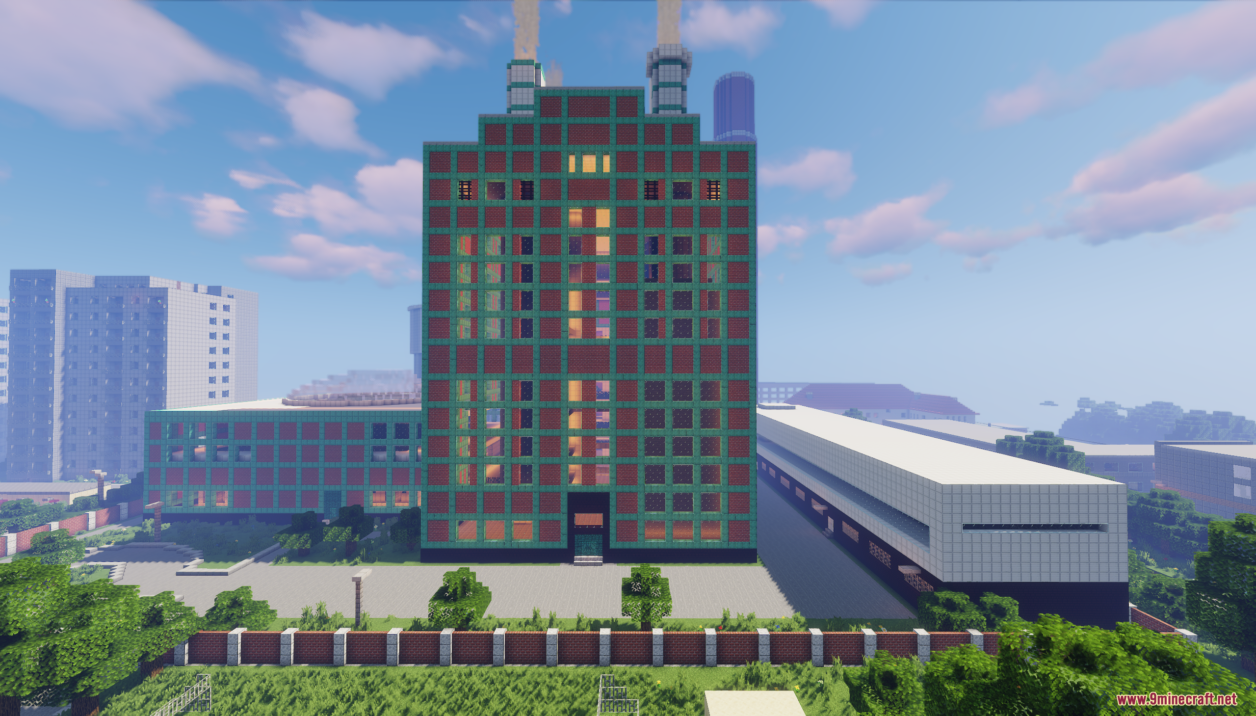 A large industrial building with red and green brick walls and two chimneys
