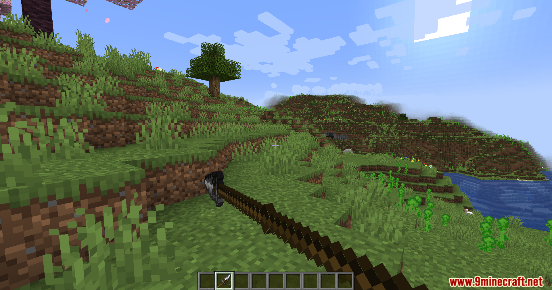 Jerotes Warehouse Mod Screenshot 6 A player points a long pike weapon towards a grassy hill in Minecraft