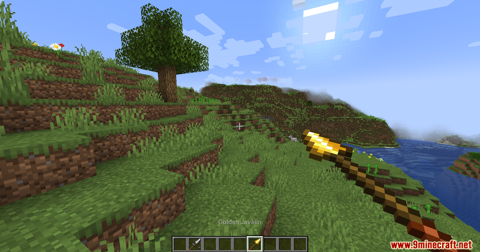 Jerotes Warehouse Mod Screenshot 8 A player holding a Golden Javelin weapon in a scenic Minecraft landscape