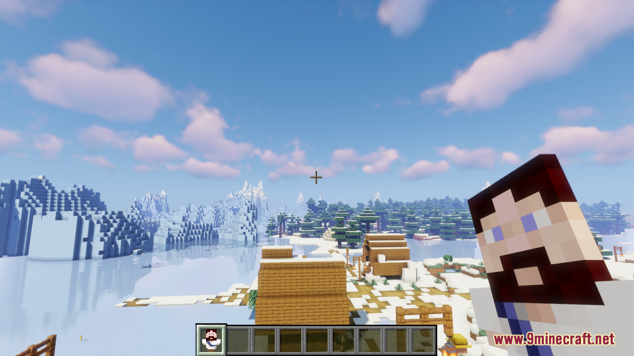 A player holds the Jesus Totem item while exploring a snowy Minecraft village
