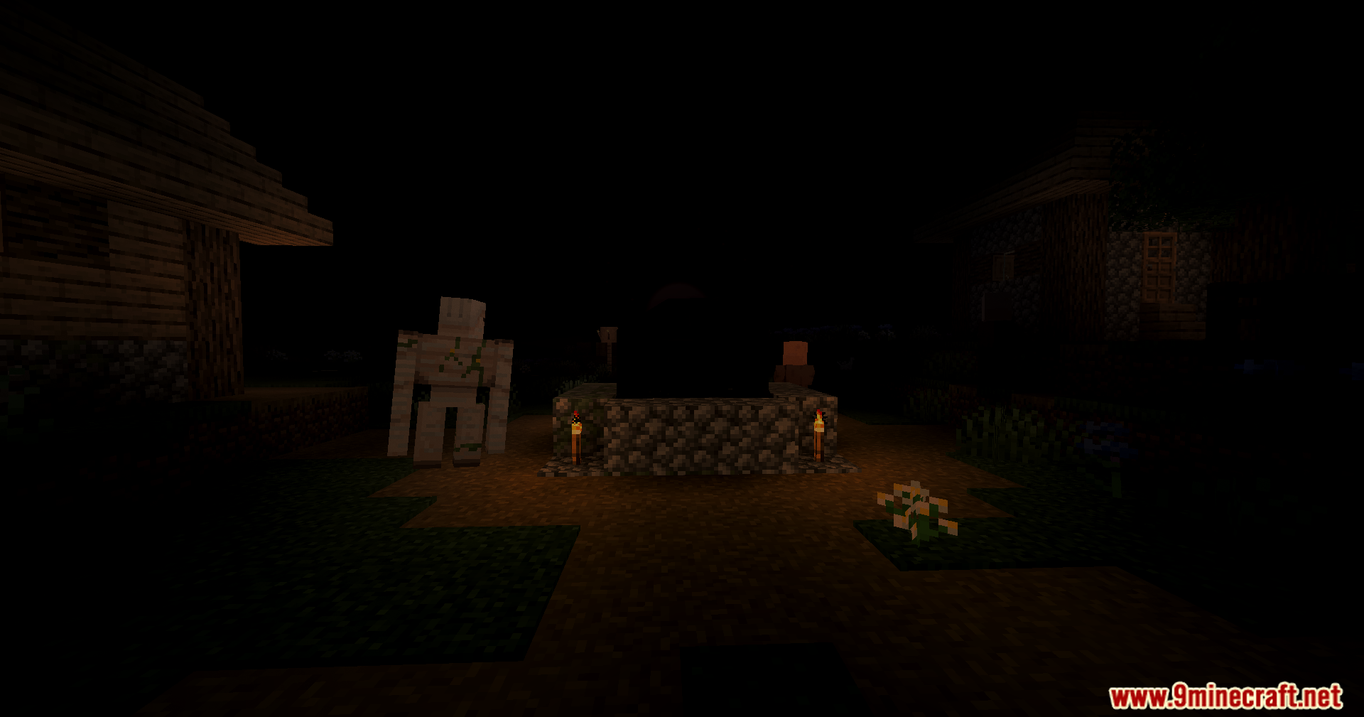 An iron golem standing near a well lit by torches in complete darkness