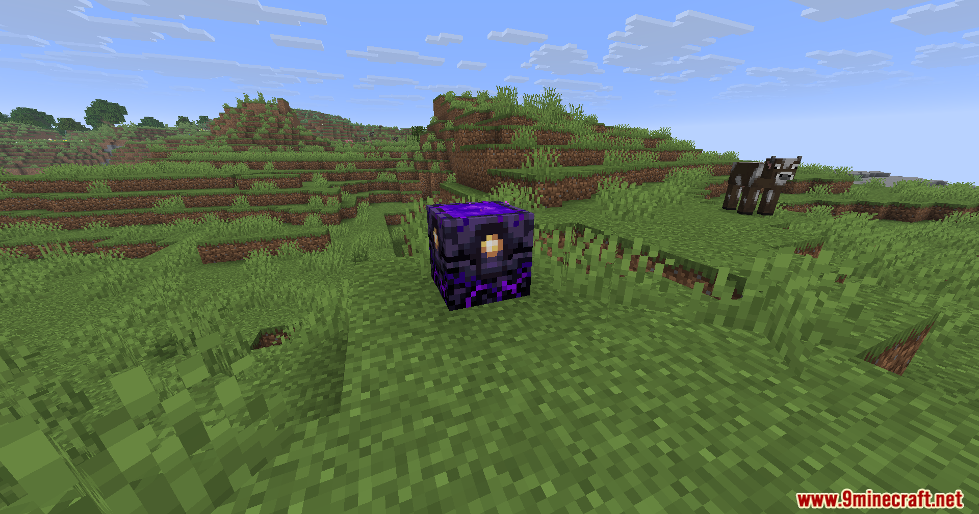 A charged Respawn Anchor block sitting on the grass in Minecraft