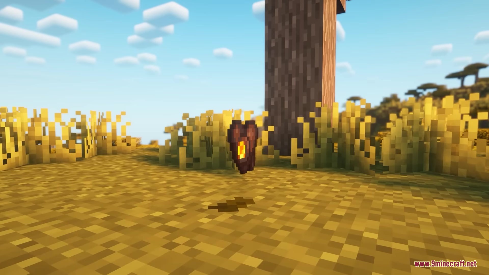 A glowing synthetic organ item floats above the ground in a savanna biome