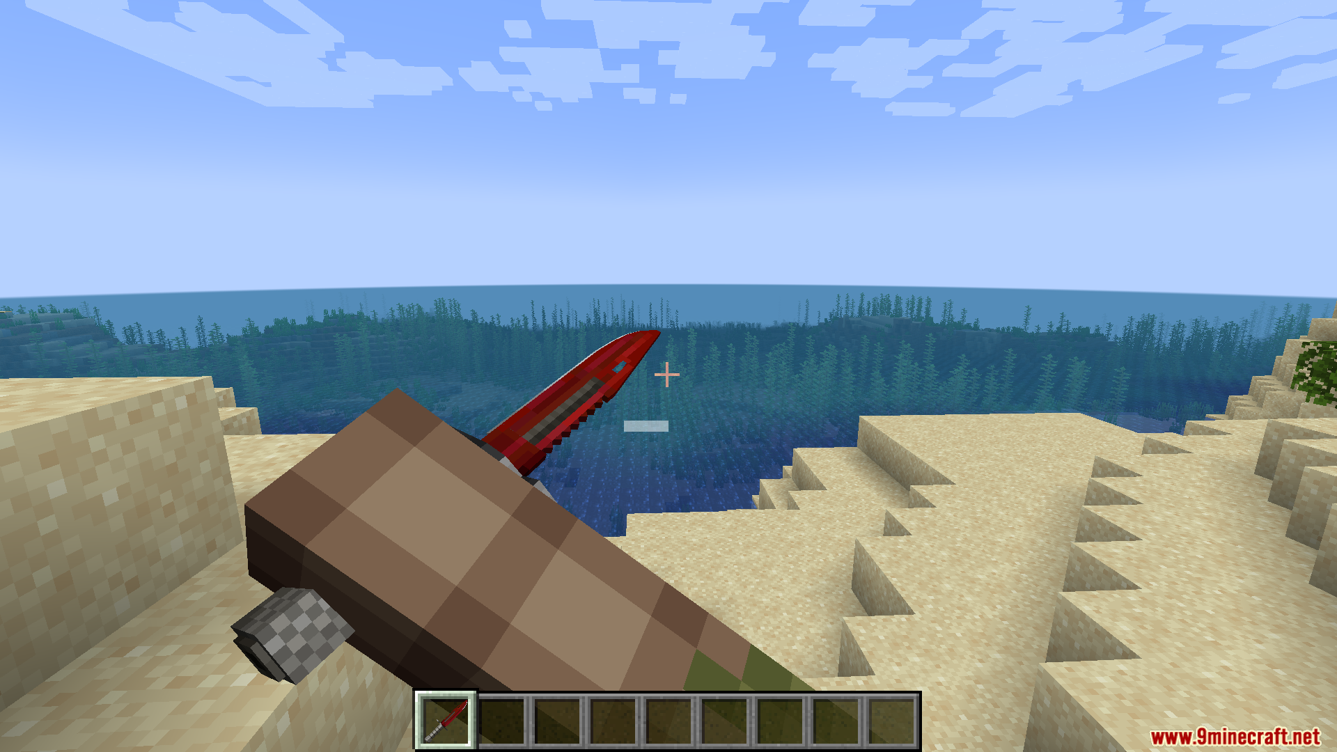 Minecraft player inspecting a red M9 Bayonet knife while standing on the sand