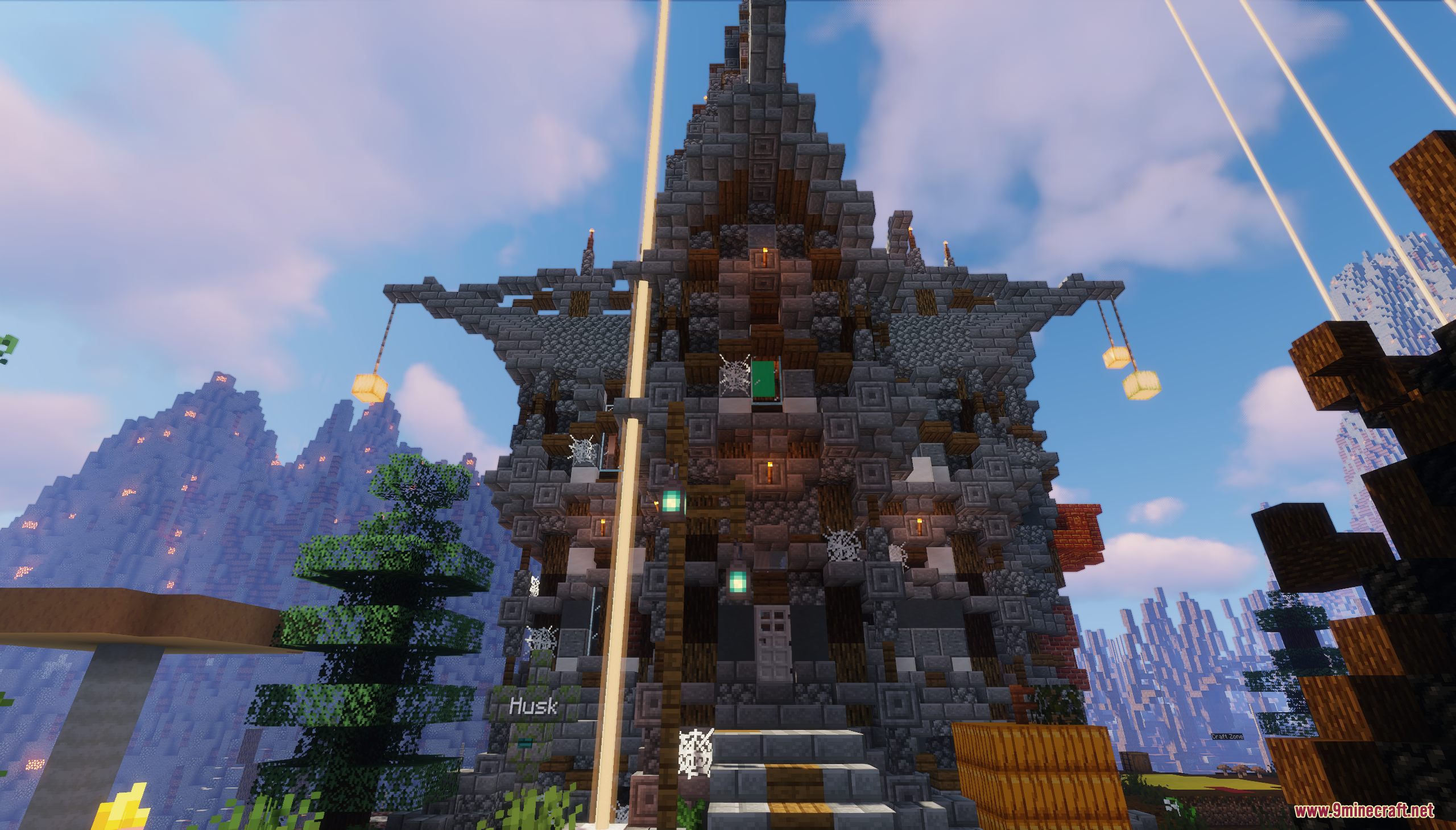 A large stone building with hanging lanterns and cobwebs in a mountain biome
