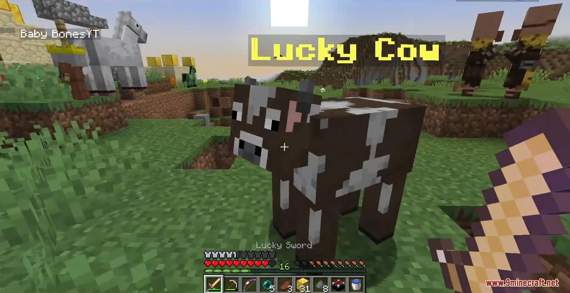 A brown cow named Lucky Cow stands in a grassy field near villagers