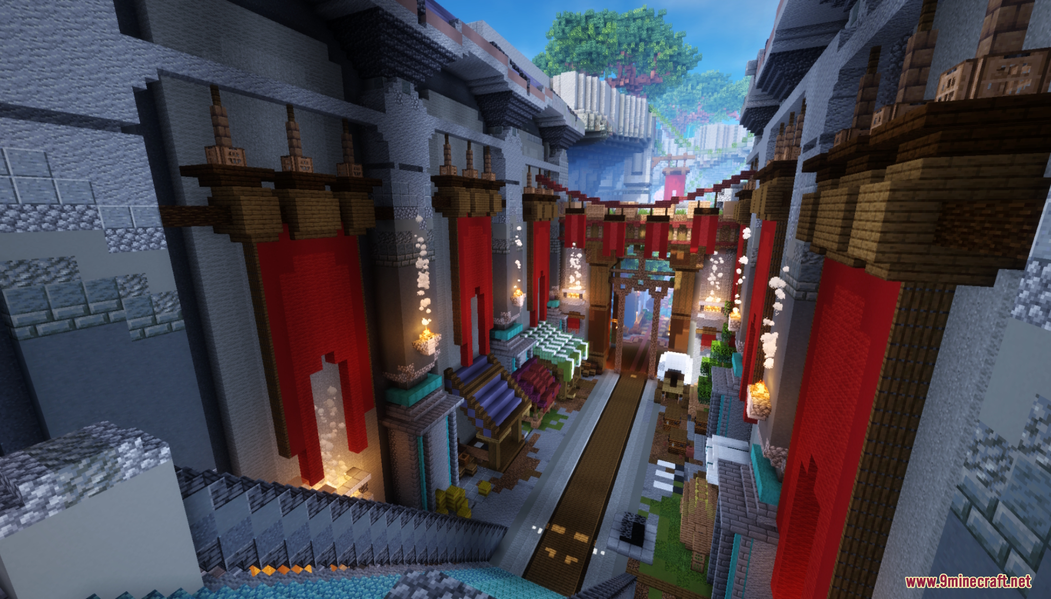 A narrow city street with tall stone buildings and large red banners
