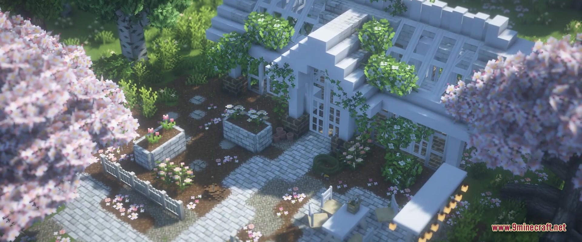 A cozy white greenhouse with cherry blossom trees and stone garden paths
