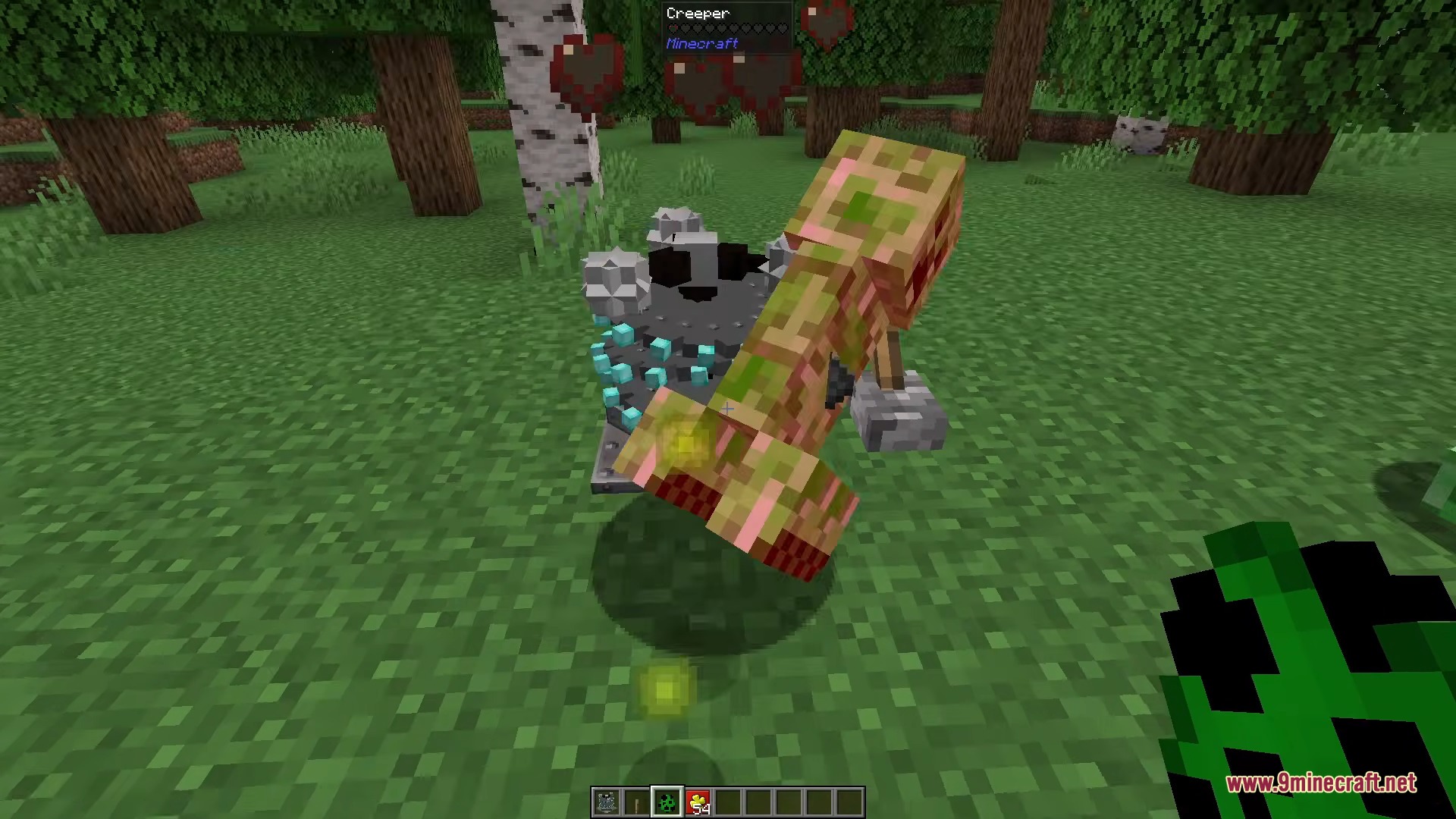 A player is attacking a creeper in a forest with experience orbs nearby