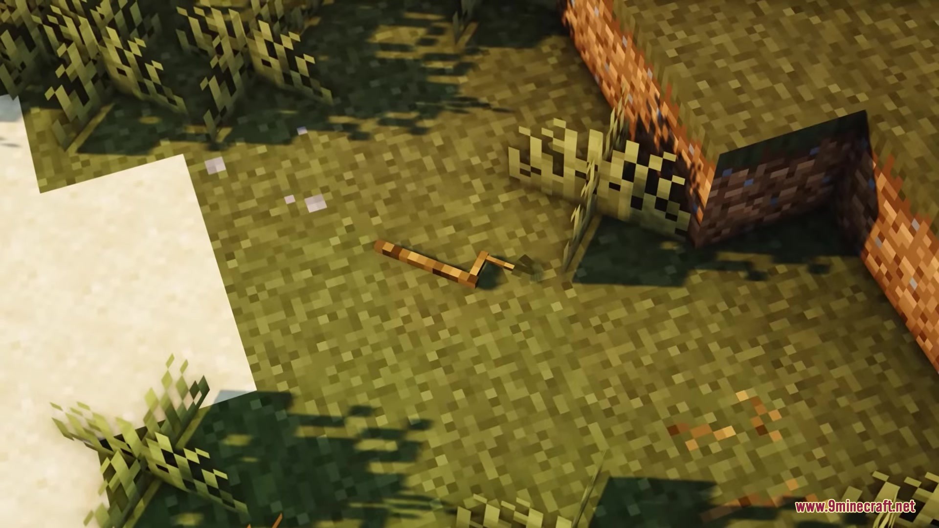 Musgo Resource Pack Screenshot 3 A detailed wooden stick item lying on the grass in Minecraft
