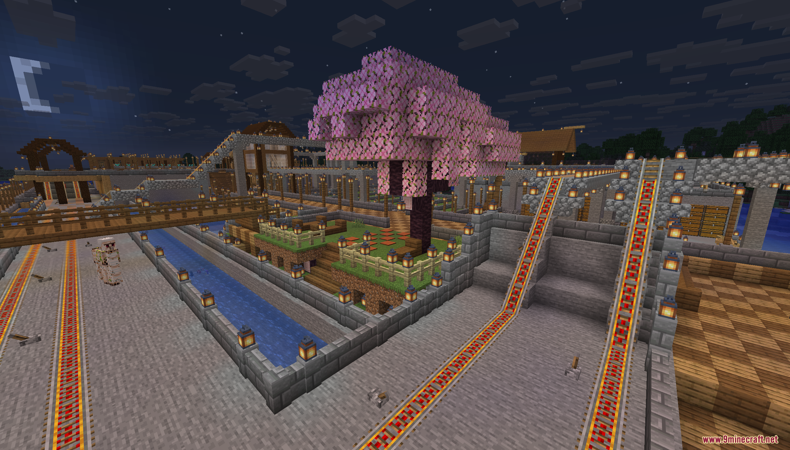 Powered rail tracks run past a pink cherry blossom tree at night