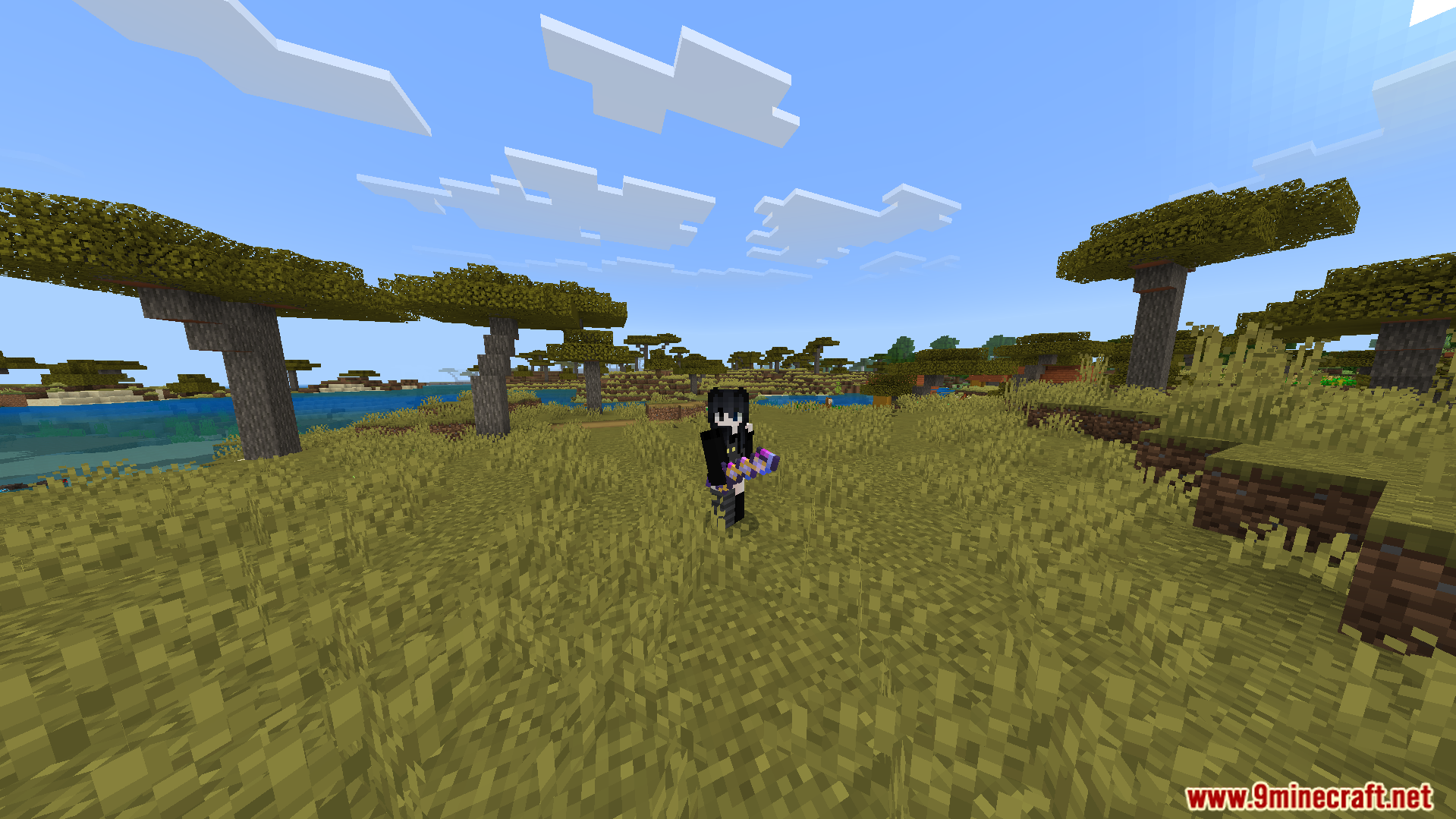 NasaRemixs Elemental Swords Addon Screenshot 4 A player character stands in a savanna biome holding a magical purple weapon