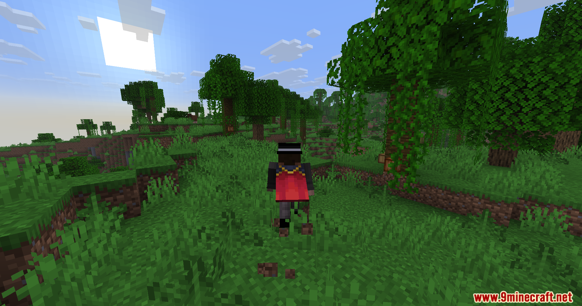 A player character with a red cape walks through a dense jungle forest