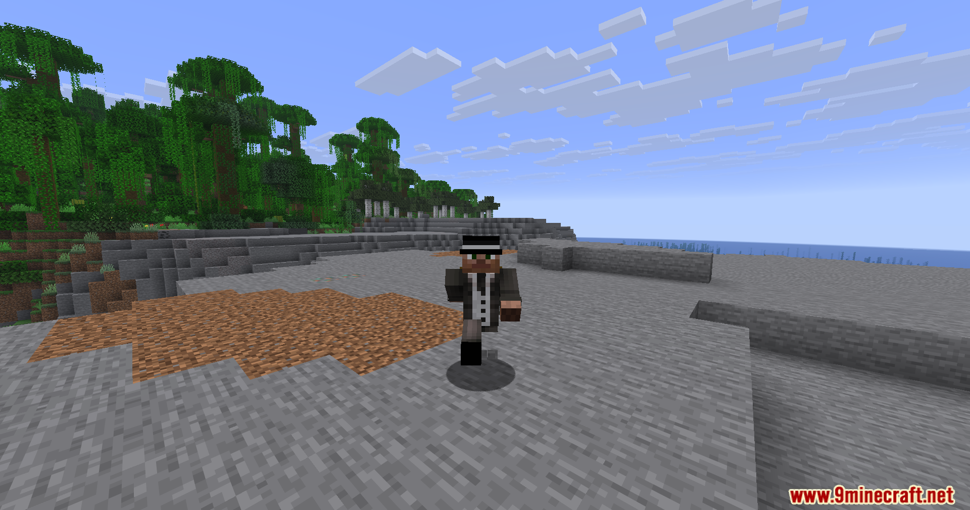 A player in a suit and hat walks through a rocky jungle biome