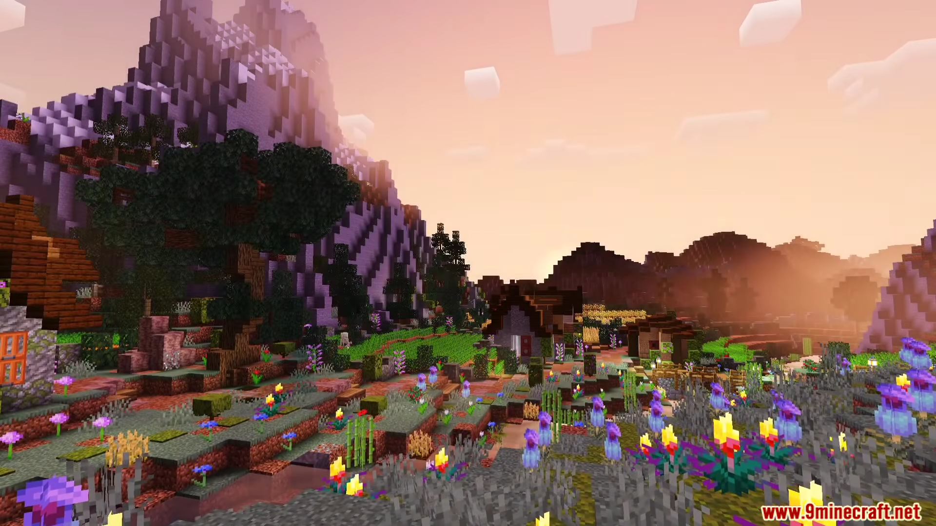 Vibrant flowers and a cozy village sit beneath a towering mountain at dusk