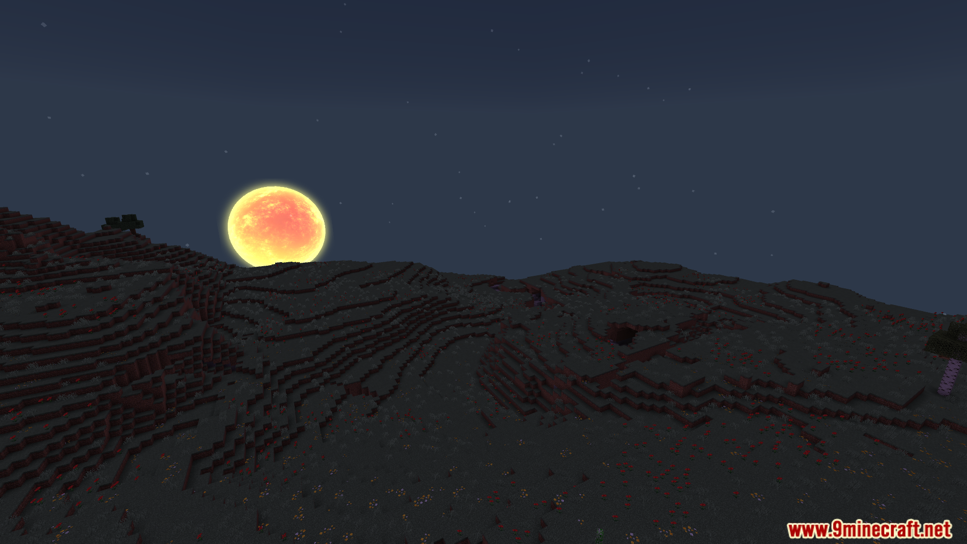 Large glowing orange moon rising over dark hills under a starry sky