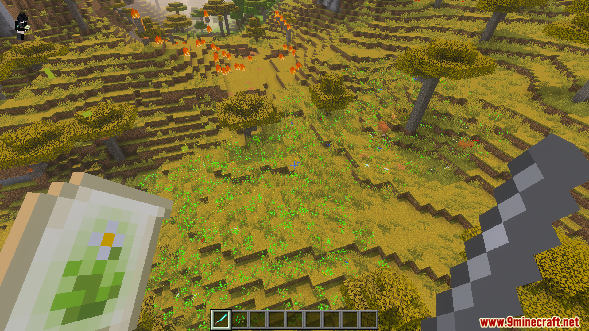 Nicos Magic Spells Addon Screenshot 9 Player holding a magic spell scroll and sword in a savanna biome